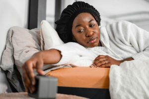Woman in bed switching alarm clock off
